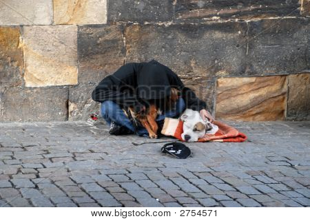 Kapuzen Obdachloser, Kopf nach unten und seinem Hund auf dem Kopfsteinpflaster