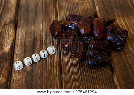 Dried Dates Lie On A Wooden Table, Next To The Explanatory Inscription. High-calorie Foods.