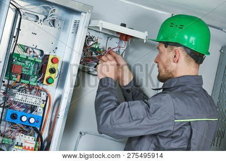 Electrician make maintenance in engine room of elevator