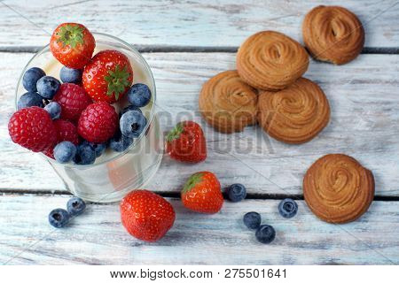 Panakota With Berries In A Glass, Biscuits Lying On A Wooden Table, Top View, Layout.