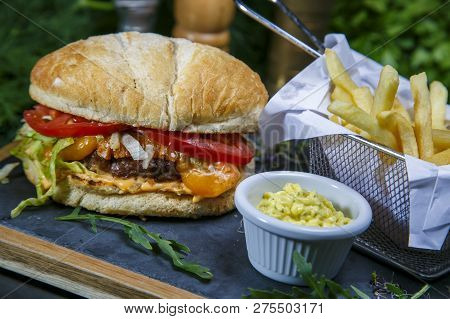 Craft Beef Burger And French Fries On Wooden Table Isolated On Black Background.