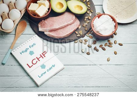 Lchf Concept. Notepad With Text And Dietary Food On Light Table.