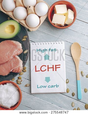 Lchf Concept. Notepad With Text And Dietary Food On Light Table.