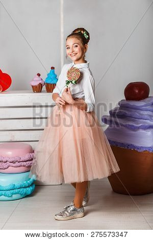 Beautiful Teenage Girls In Pink Tutu Skirts With Lollipops And Macaroons And Fansy Cakes In Studio O