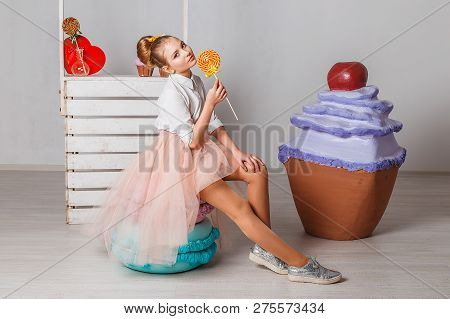 Beautiful Teenage Girls In Pink Tutu Skirts With Lollipops And Macaroons And Fansy Cakes In Studio O