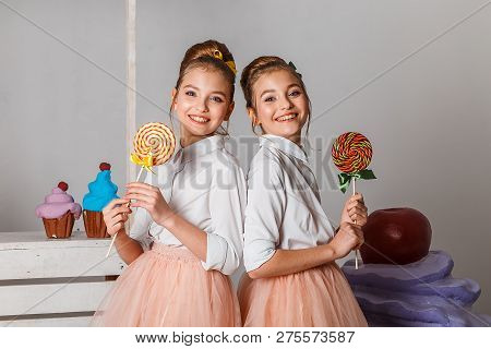 Beautiful Teenage Girls In Pink Tutu Skirts With Lollipops And Macaroons And Fansy Cakes In Studio O