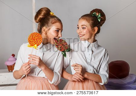 Beautiful Teenage Girls In Pink Tutu Skirts With Lollipops And Macaroons And Fansy Cakes In Studio O