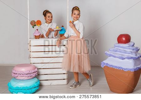 Beautiful Teenage Girls In Pink Tutu Skirts With Lollipops And Macaroons And Fansy Cakes In Studio O