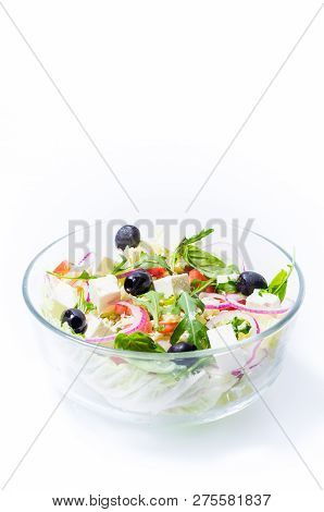 Salad from vegetables and olives. Salad in a transparent bowl. Salad isolate. Vertical frame.