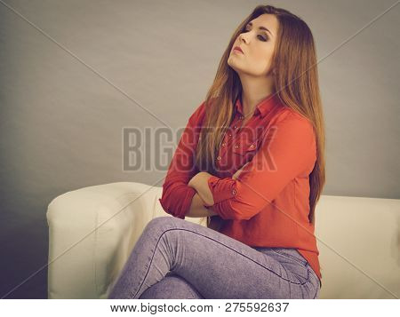 Angry, Pissed Off Young Woman. Attractive Female With Long Brown Hair Sitting On Sofa Being Mad And 
