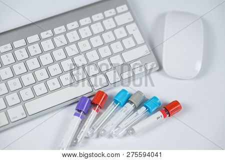 Medicine Bottles For Samples Next To Computer Tablet And Computer Keyboard In Medicine, Closeup On W