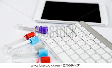 Medicine Bottles For Samples Next To Computer Tablet And Computer Keyboard In Medicine, Closeup On W