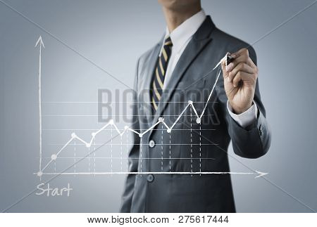 Business Growth, Progress Or Success Concept. Businessman Is Drawing A Growing Graph On Bright Tone 