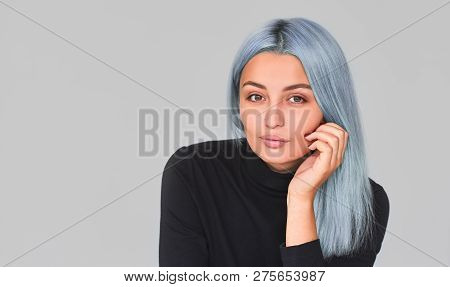 Studio Portrait Of Young Female With Blue Hair Posing In Studio Looking To The Camera. Teenager Woma