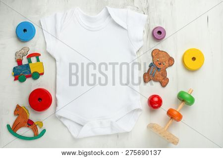 Layout Flat Lay White Baby Shirt Bodysuit On, White Background With Children's Toys. Mock Up For The