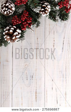 Spruce Branches, Cones And Red Berries On A White Wooden Background. Background For Christmas And Ne