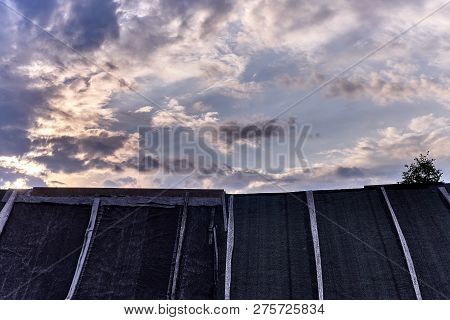 Old Roof Of A Russian Bath Against The Evening Cloudy Sky