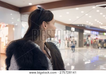 Close Up Of A Young Brunet Girl In Shopping Mall Looking Away From The Camera. Good-looking Woman St
