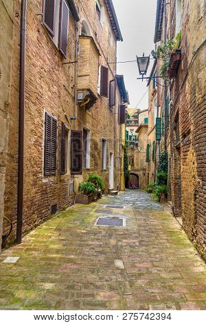 Medieval Narrow Street Vicolo Degli Orefici In Old City Siena, Tuscany, Italy.