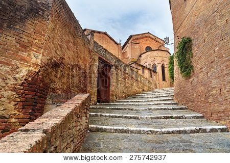 Stairs On The Street Via Val Di Montone And Basilica Santa Maria Dei Servi In Old City Siena. Italy