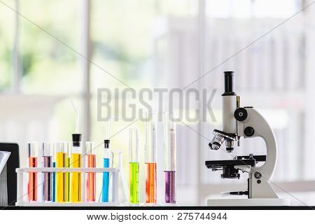 Coloful Teast Tube And Microscope On Table In Laboratory Room, Blurred Background, Concept For Labor