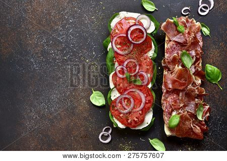 Italian Sandwith With Prosciutto Crudo, Mozzarella Cheese, Salami And Basil .top View With Copy Spac