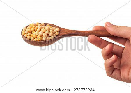 Spoon In Hand With Yellow Peas On White Background