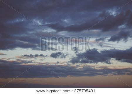 Evening Sky Scene With Golden Light From The Setting Sun And Blue-tinting Filled With Cloud Streaks,