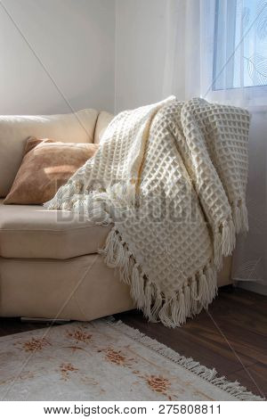Stylish Brightly Interior Of Living Room. Inviting Comfortable Sofa With Handmade Woolen Blanket. Co
