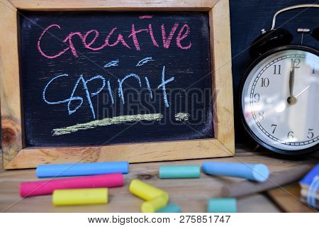 Creative Spirit. Back To School Concept. Alarm Clock On Wooden With Blackboard On Background