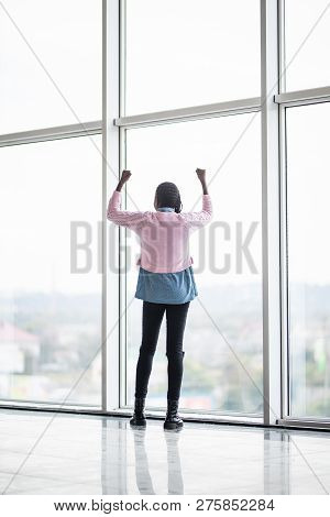 Full Height Afro American Woman With Reised Hands Up Standing In Front Of Pamoramic Window Of Celebr