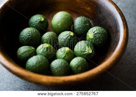 Immature Unripe Organic Green Limes In Wooden Bowl.