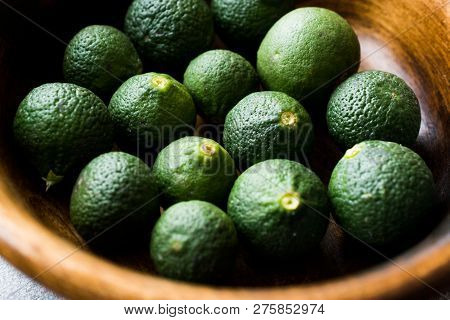 Immature Unripe Organic Green Limes In Wooden Bowl. Organic Food.