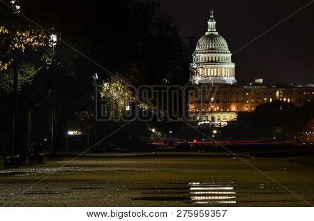 Washington DC at night - United States Capitol and reflection on rain puddle