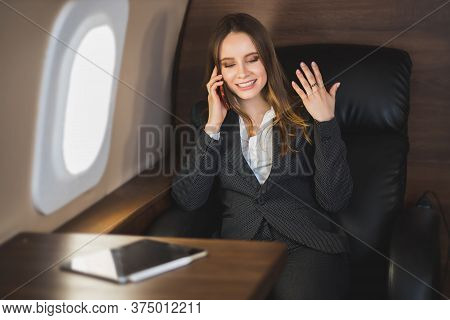 Cheerful Happy Brown Haired Business Lady In White Blouse And Formal Suit, Sitting In Comfortable Se