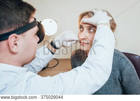 Otolaryngologist Examines Womans Nose With Nasal Dilator.