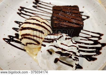 Close-up Shaped Chocolate Lava Cake With Syrup And Vanilla Sweet Ice Cream Decorated With Dark Cholo