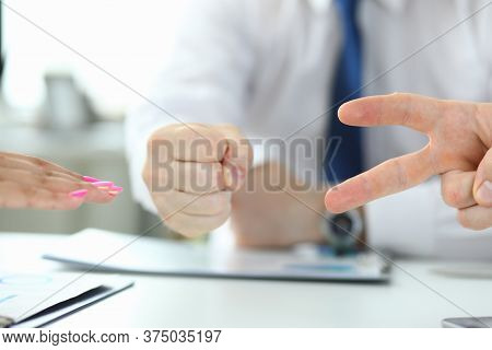 Close Up Of Table With Group Of People Playing Rock Paper Scissors Game In The Office. Rock, Paper, 