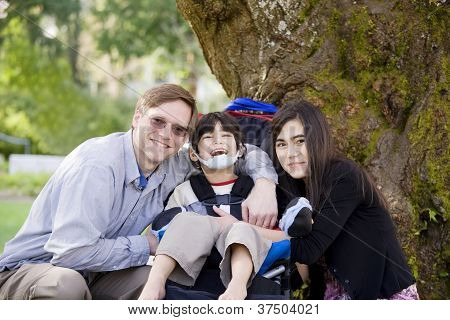 Engelli çocuk babası ve kız kardeşi tarafından çevrili Wheelcahir