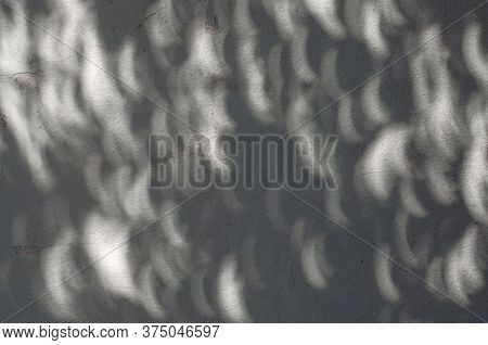 Shadow Of Solar Eclipse On Concrete Wall, Solar Eclipse Shape Spots Of Sunlight On The Wall During A