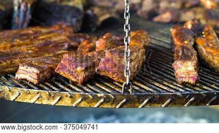 Crusty Pork Ribs Roasting On Grill Outside