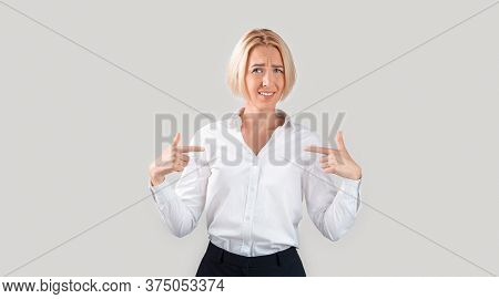 Ageism Concept. Mature Business Lady Pointing Questioningly At Herself, Unhappy With Nomination Or D