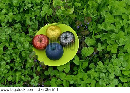 Painted Or Poisonous Magical Apples On The Plate In The Clover Grass. Esoteric, Gothic And Occult Ba