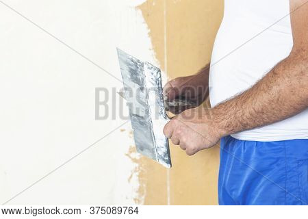 Hand With Putty Knife Repair Wall, Hand With A Spatula, Spatula With Spackle Paste Structure, Proces