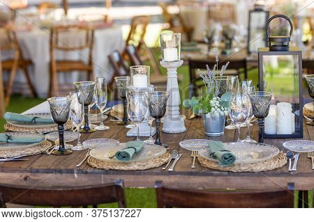 Wooden Table With Plates, Cutlery And Decoration For A Boho Hipster And Vintage Style Event Or Weddi