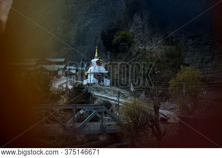 Buddhist Stupa Seen Through Prayer Flags In Chame Mountain Village, Trekking Annapurna Circuit, Nepa
