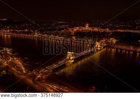 Aerial Drone Shot Of Chain Bridge Over Danube And National Gallery With Lights In Budapest Night