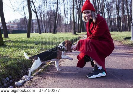 Pretty Young Girl In Redd Coat Playing With Dog Outside In Green Park, Lifestyle People Concept
