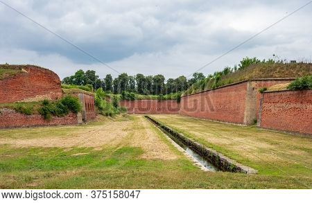 The Water Canal And Red Bricks Wall Outside The Former Terezin Concentration Camp, Czech Republic