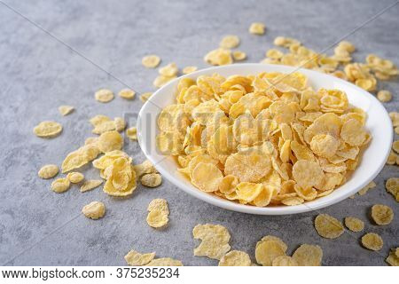 Corn Flakes Bowl Sweeties With Milk On Gray Cement Background, Close Up, Fresh And Healthy Breakbast